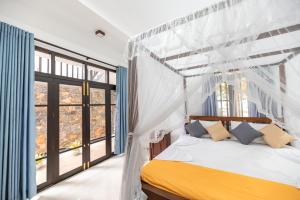 a bedroom with a canopy bed and a window at Hotel Calm Haven in Galle