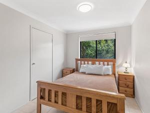 a bedroom with a large bed and a window at Fingal Sands 10A Fingal Bay in Fingal Bay
