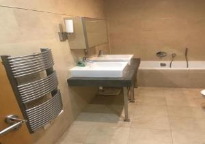 een badkamer met een wastafel en een bad bij SEA AIR OCEAN VILLAGE in Gibraltar