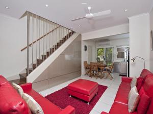 a living room with a red couch and a red stool at Florida 5 5 Lillian Street in Shoal Bay