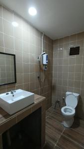 ein Badezimmer mit einem Waschbecken, einem WC und einem Spiegel in der Unterkunft Drym Valley Langkawi in Pantai Cenang