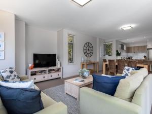 a living room with two couches and a tv at Aqua View by Jervis Bay Rentals in Huskisson