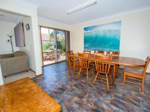 a dining room with a table and chairs at Government Rd 63 Shoal Bay in Shoal Bay