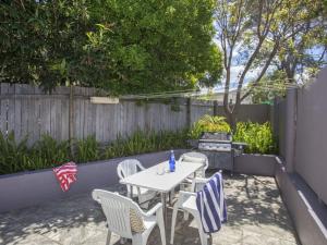 a patio with a table and chairs and a grill at Harbour Breeze in Ulladulla