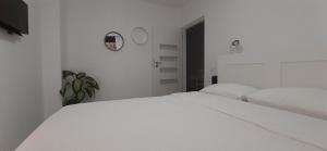 a white bedroom with a large white bed in it at Adma Apartments in Sibiu