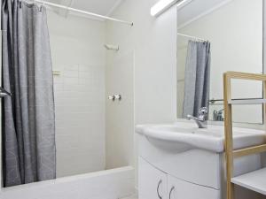 a white bathroom with a sink and a shower at Fairwater In Mollymook in Mollymook