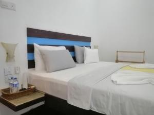 a bedroom with a large white bed with white pillows at Le Petit Hotel & Restaurant in Negombo