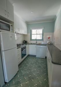a kitchen with white appliances and a tile floor at Altitude Apartment 2 in Baw Baw Village