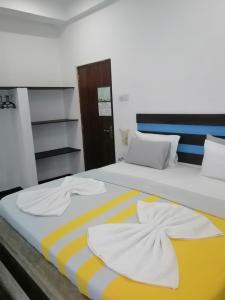 two beds with towels sitting on top of them at Le Petit Hotel & Restaurant in Negombo