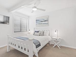 a white bedroom with a bed and a ceiling fan at Seahaven Unit 1 Shoal Bay Road 81 in Shoal Bay