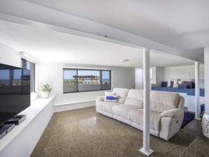 a white living room with a couch and a bed at Bawley Point Beach Front in Bawley Point