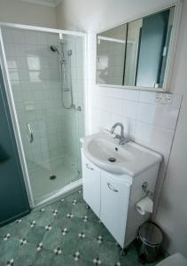 y baño blanco con lavabo y ducha. en Altitude Apartment 1 en Baw Baw Village