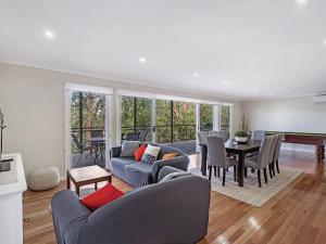 a living room with a blue couch and a dining room at Tallean Road 71 in Nelson Bay