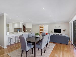 a dining room and living room with a table and chairs at Tallean Road 71 in Nelson Bay