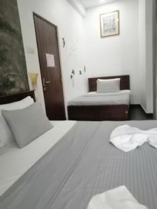 a hotel room with two beds and a door at Le Petit Hotel & Restaurant in Negombo
