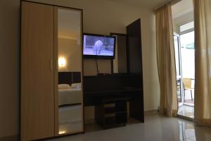 una stanza con uno specchio e una tv e una camera da letto di Solar Apartments a Herceg-Novi