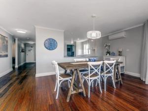 a kitchen and dining room with a wooden table and chairs at The Anchorage Unit 12 9 Laman Street in Nelson Bay