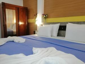 a bedroom with two beds with blue sheets and white pillows at Le Petit Hotel & Restaurant in Negombo