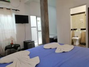 a bedroom with a blue bed with towels on it at Le Petit Hotel & Restaurant in Negombo