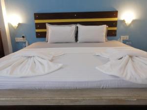a large white bed with white sheets and pillows at Le Petit Hotel & Restaurant in Negombo +37 photos