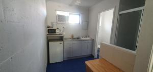 a kitchen with a sink and a refrigerator at Bargara Motor Inn - Pet Friendly in Bargara