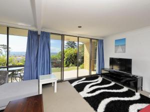 a living room with a television and a rug at The Crest Unit 5 6 8 Tomaree Road in Shoal Bay