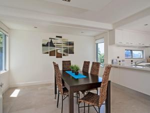 a dining room with a table and chairs at The Domain Unit 2 19 Voyager Close in Nelson Bay