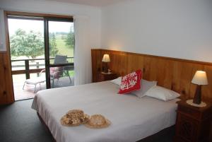 a bedroom with a bed with two teddy bears on it at Coast Norfolk Island in Burnt Pine