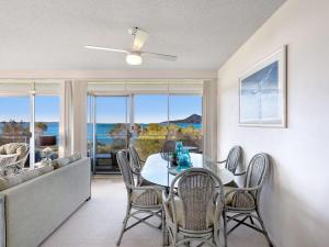 a dining room with a table and chairs and a couch at The Helm 4 22 Voyager Close in Nelson Bay