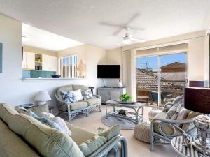a living room with a couch and chairs and a tv at The Helm 4 22 Voyager Close in Nelson Bay
