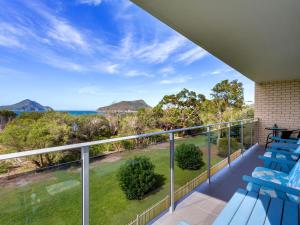a balcony with blue chairs and a view of the ocean at The Helm 4 22 Voyager Close in Nelson Bay