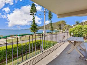 a picnic table on a balcony with a view of the ocean at Shoal Towers Unit 3 11 Shoal Bay Road in Shoal Bay