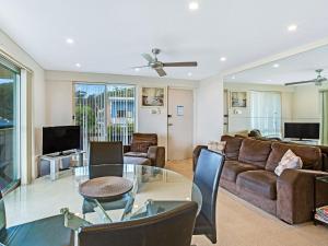 a living room with a couch and a glass table at Shoal Towers Unit 3 11 Shoal Bay Road in Shoal Bay