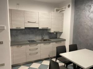 a kitchen with white cabinets and a table with chairs at Vecchia Mori in Mori