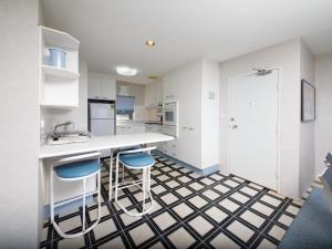 a kitchen with a counter and two stools at Shoalhaven Unit 6 28 Voyager Close in Nelson Bay