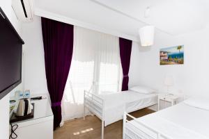 een witte kamer met een bed en een raam bij Ayka Hotel in Akyaka