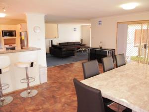 a kitchen and living room with a table and chairs at Seaside Serenity Soldiers Point in Soldiers Point