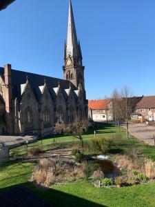 una iglesia con una torre de reloj en un campo en Fernweh Harz, en Seesen