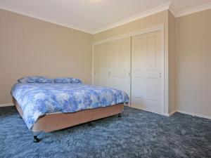 a bedroom with a bed with a blue comforter at Bring the Dog, Boat and Family in Burrill Lake