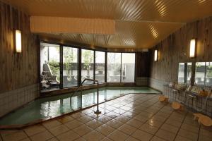 a swimming pool in a building with a pool at Tsuki no Shizuka in Matsumoto