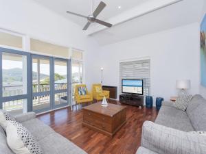 a living room with two couches and a flat screen tv at Surf Break Unit 10B Tuna Cresent Upstairs in Fingal Bay