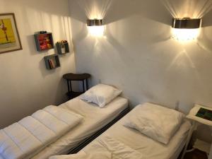 2 camas en una habitación con luces en la pared en Villa La Mer - maison typique et jardin à Berck-Plage à 300 m de la mer en Berck-sur-Mer