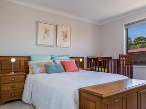 a bedroom with a bed and a table and a window at Ocean Views in Mollymook