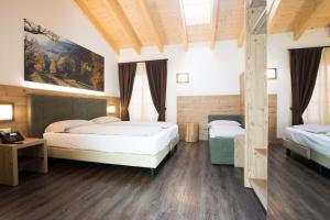 - une chambre avec 2 lits et un tableau mural dans l'établissement TOURING HOTEL & SPA, à Edolo