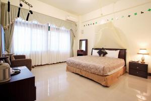 1 dormitorio con 1 cama, 1 sofá y 1 silla en Green Window Homestay, en Hualien City