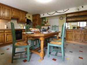cocina con mesa de madera y sillas verdes en Gîte Thoras, 5 pièces, 8 personnes - FR-1-582-301 en Thoras