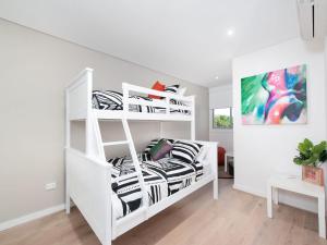 een wit stapelbed in een witte kamer bij The Shoal Apartments, Unit 201/4-8 Bullecourt Street in Shoal Bay