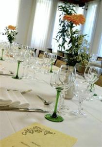 a table with wine glasses and flowers on it at Albergo Ristorante Cicin in Casale Corte Cerro