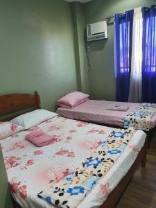 2 nebeneinander sitzende Betten in einem Schlafzimmer in der Unterkunft Casa Sarmiento Travellers Inn in Laoag
