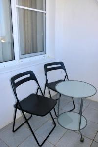 two chairs and a table next to a window at Mini-Hotel Morskoi rif in Golubitskaya